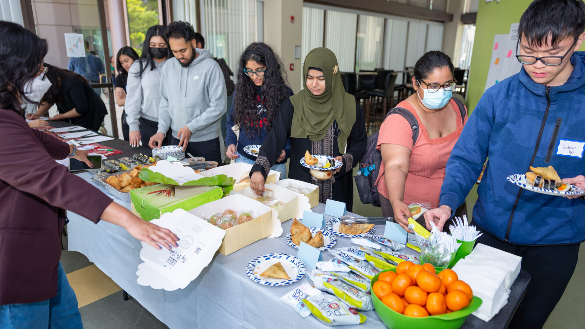 Queens College students getting refreshments from local Queens restaurants at the QCAP + AAARI AAPI Heritage Month Celebration